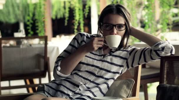 Женщина пьет кофе в кафе — стоковое видео