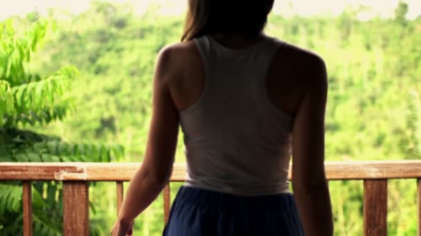 Frau geht auf Terrasse hinaus — Stockvideo