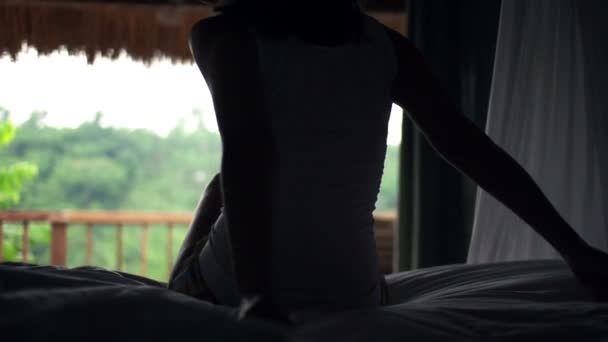 Жінка залишає ліжко, прокидається на терасі і розтягує руки — стокове відео