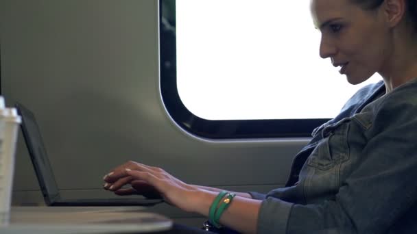 Женщина работает на ноутбуке во время поездки на поезде — стоковое видео