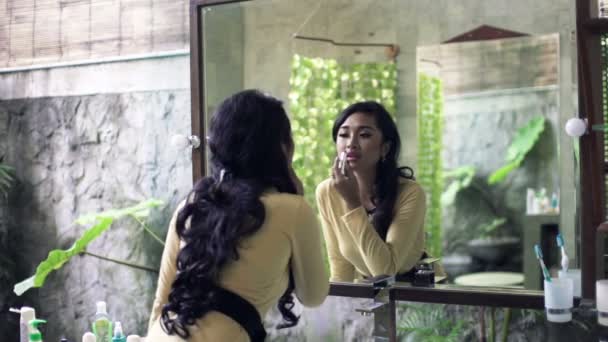 Женщина наносит помаду перед зеркалом — стоковое видео