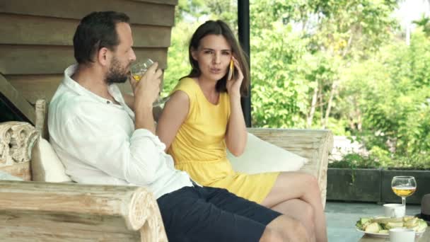 Casal com telefone celular bebendo vinho no terraço — Vídeo de Stock