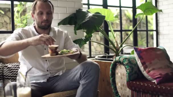 Man eating sandwich in cafe — Stock Video