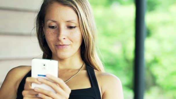 Frau verschickt SMS, SMS auf Smartphone — Stockvideo