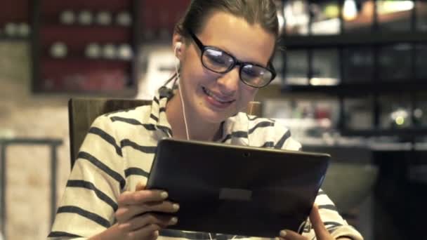 Женщина смотрит фильм на планшетном компьютере — стоковое видео