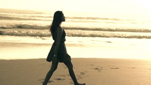 Vrouw lopen op strand tijdens zonsondergang — Stockvideo