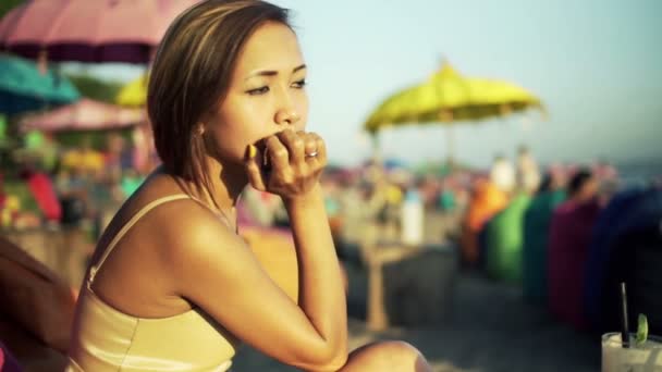 Mujer infeliz sentada en el puf en la playa — Vídeo de stock