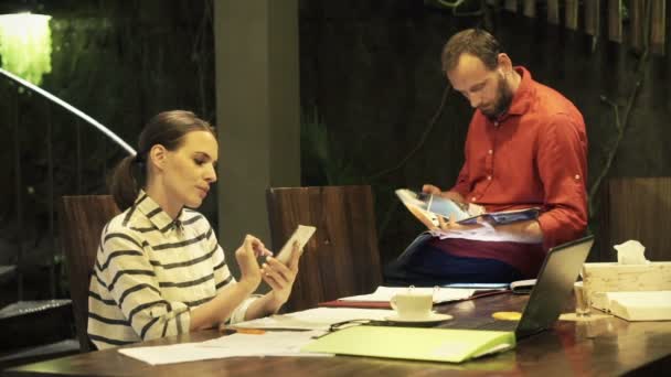 Couple utilisant un smartphone et un magazine de lecture — Video