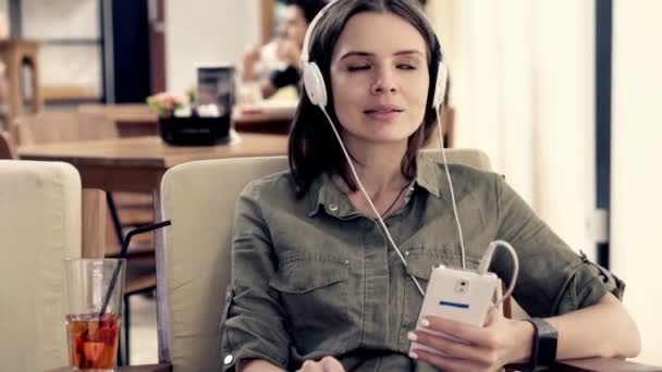 Kobieta słuchać muzyki i picia koktajl — Wideo stockowe