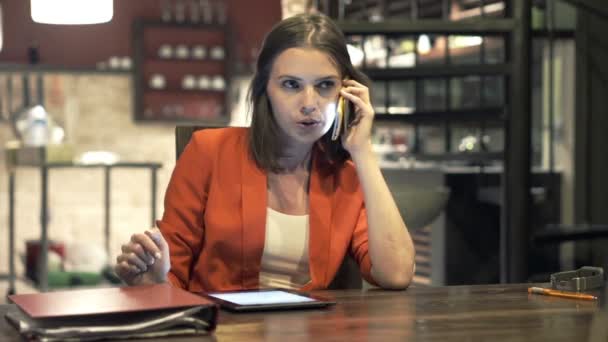 Деловая женщина с планшетным компьютером разговаривает по мобильному телефону — стоковое видео