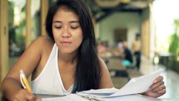 Female student doing homework in cafe — Stock Video