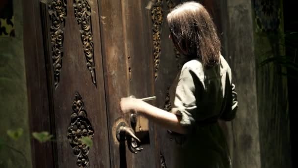 Mujer llamando a la puerta de entrada de madera — Vídeos de Stock