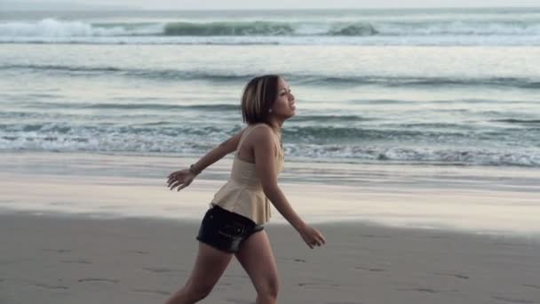 Mujer corriendo a lo largo de playa — Vídeo de stock