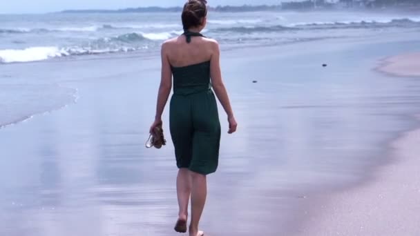 Kobieta spacerująca wzdłuż plaży — Wideo stockowe