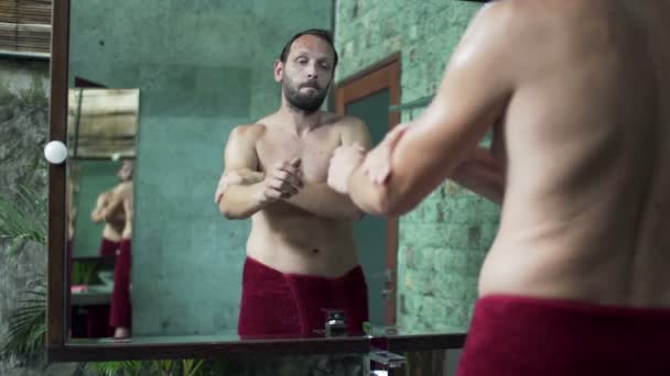 Muž použitím krém na ruce a prsa — Stock video