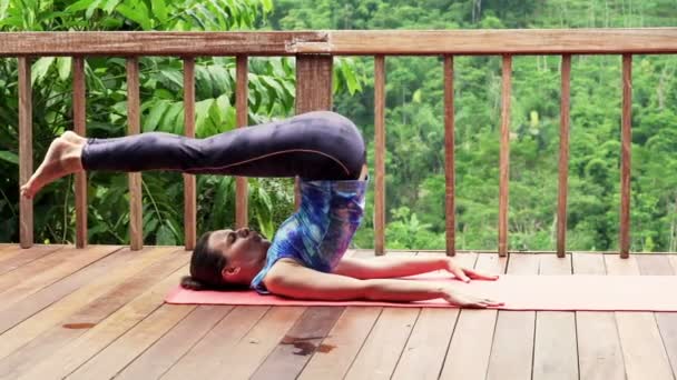 Woman exercising on mat on terrace — Stock Video