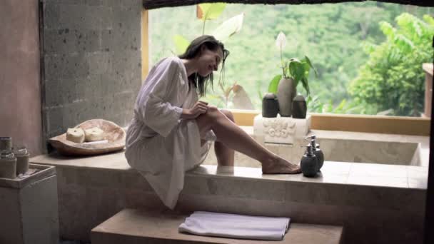 Frau im Bademantel rasiert Bein — Stockvideo