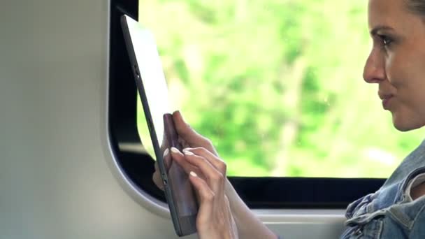 Hübsche Frau arbeitet mit Tablet im Zug — Stockvideo