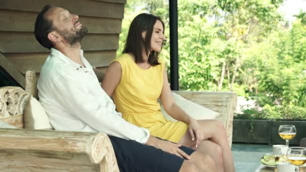 Пара отдыхает на деревянном диване — стоковое видео