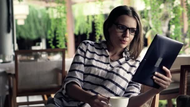 Женщина читает новости на планшетном компьютере — стоковое видео