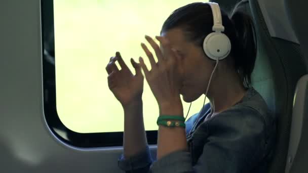 Donna che ascolta la musica durante i viaggi in treno — Video Stock