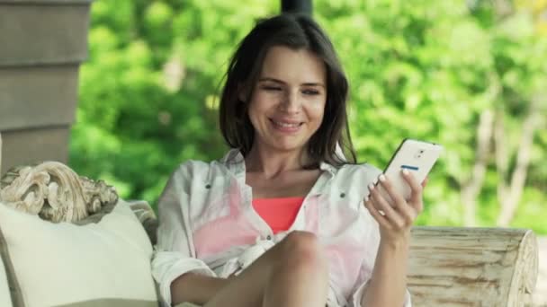 Vrouw met smartphone terras — Stockvideo