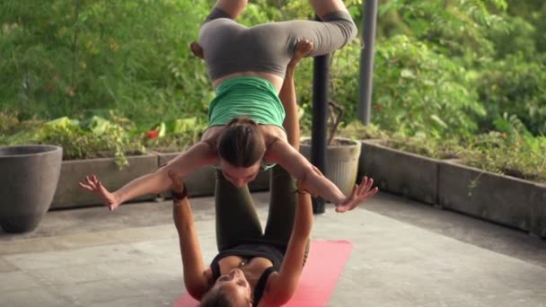 Girlfriends exercising acro yoga on terrace — Stock Video