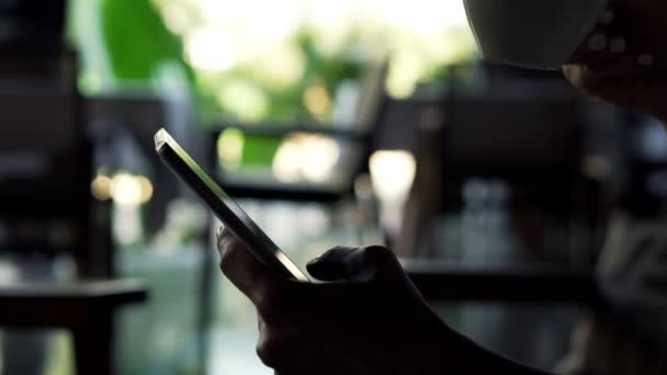 Frau mit Smartphone trinkt Kaffee — Stockvideo