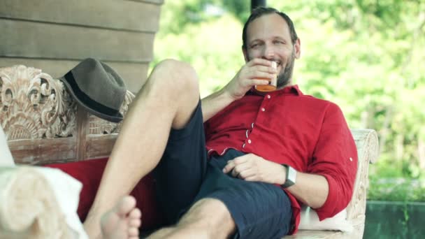 Man drinking beverage on sofa — Stock Video