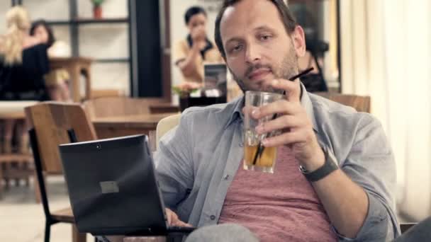 Mann mit Laptop trinkt Alkohol — Stockvideo