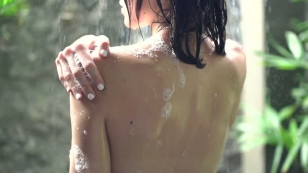 Naked woman washing body under shower — Stockvideo