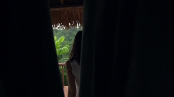Женщина просыпается на террасе и вытягивает руки — стоковое видео