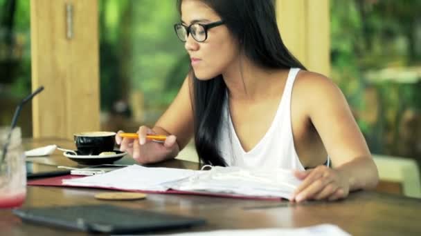 Estudante do sexo feminino fazendo lição de casa com smartphone — Vídeo de Stock