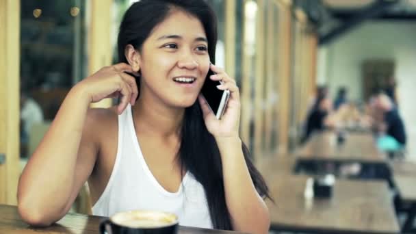 Woman talking on cellphone sitting in cafe — Stock Video