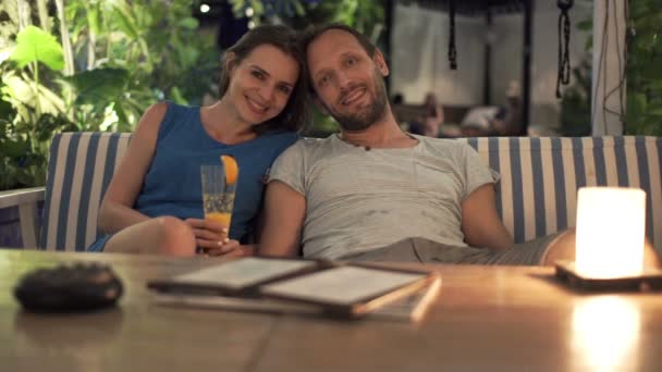 Пара, сидящая в кафе ночью — стоковое видео