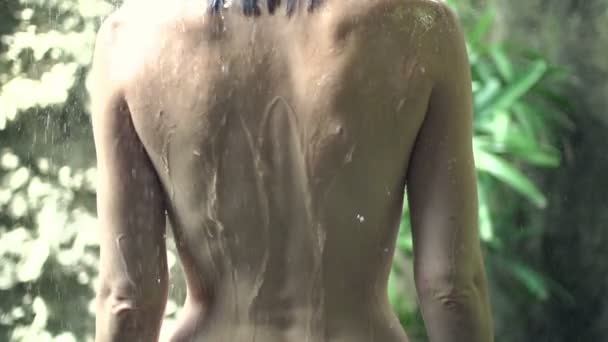 Гола жінка стоїть під душем — стокове відео