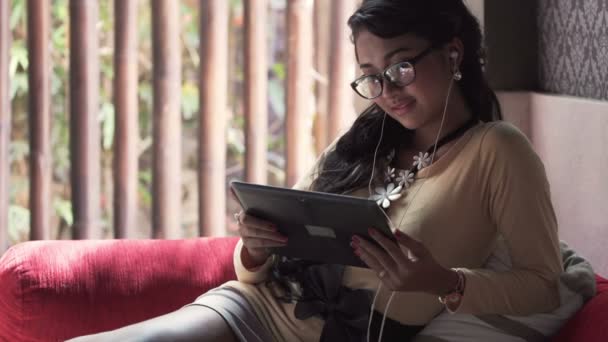 Женщина смотрит фильм на планшетном компьютере — стоковое видео