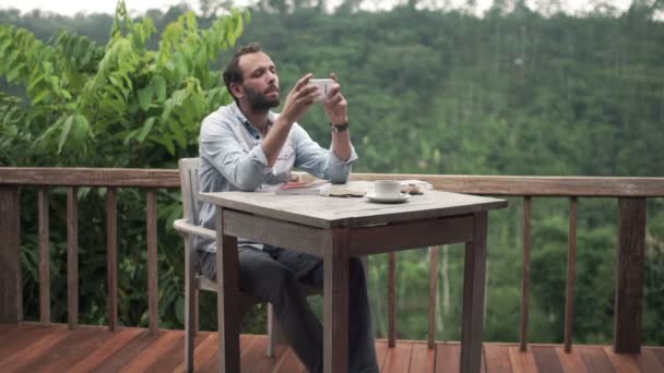 Man using smartphone and drinking coffee — Stock Video