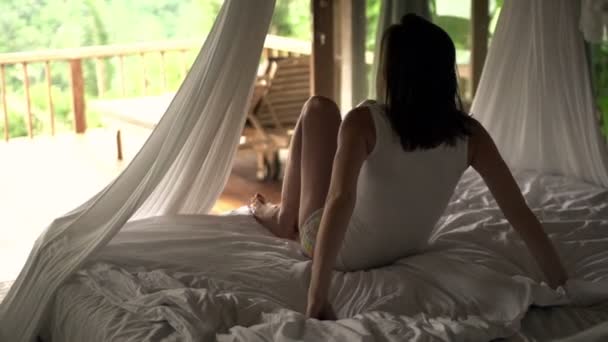 Woman leaving bed and waking out on terrace — Stock Video