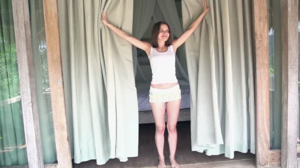 Lycklig kvinna avslöja gardiner i sovrummet — Stockvideo