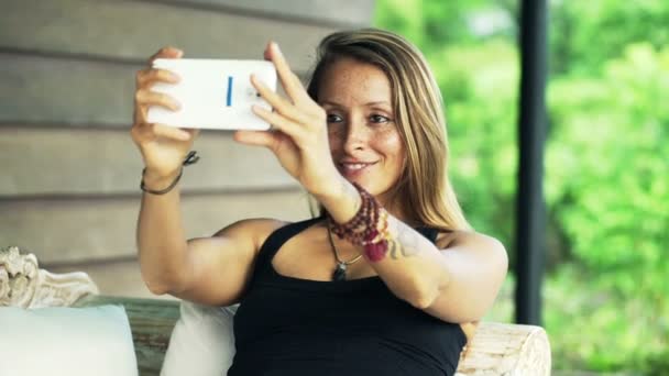 Vrouw die selfie met cellphone op Bank — Stockvideo