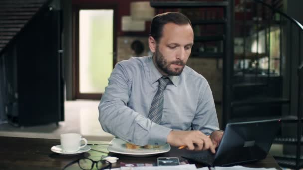 Hombre de negocios desayunando y trabajando con documentos — Vídeo de stock