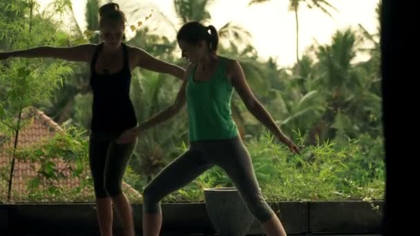 Flickvänner på terrassen utövar yoga — Stockvideo