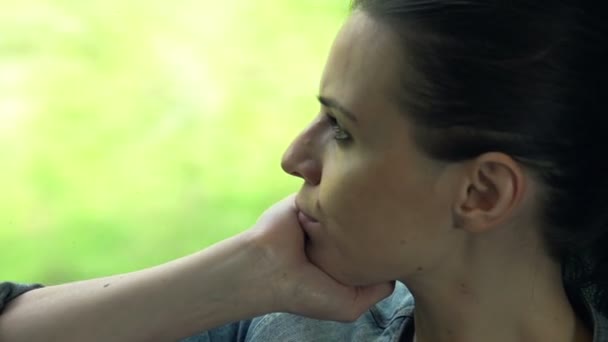 Femme regardant par la fenêtre pendant le trajet en train — Video