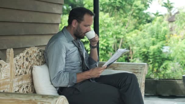 Uomo d'affari che legge giornali e beve caffè — Video Stock