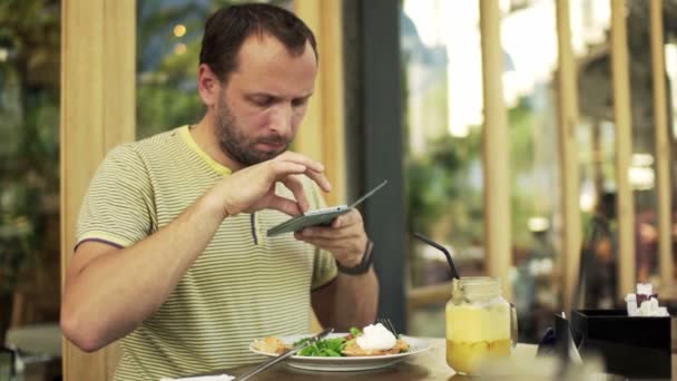 Hombre hablando foto de la comida con el teléfono celular en la cafetería — Vídeo de stock