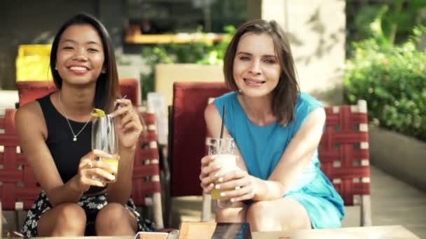 Подружки п'ють коктейлі в кафе — стокове відео