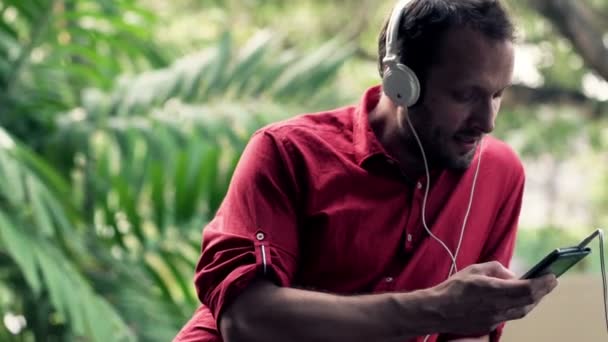 Hombre escuchando música en el teléfono celular — Vídeos de Stock