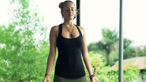Женщина медитирует стоя на террасе — стоковое видео
