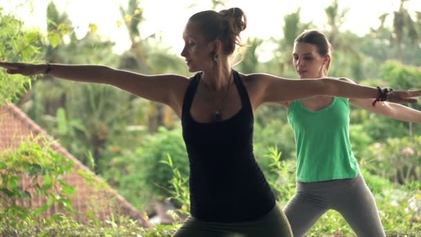 Flickvänner på terrassen utövar yoga — Stockvideo